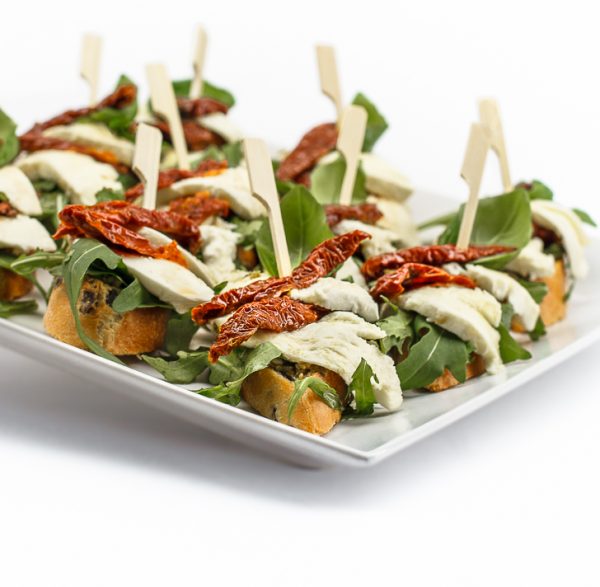 Crostini mit getrockneten Tomaten, Mozzarella, Basilikumpesto und Rucola von ehab Catering